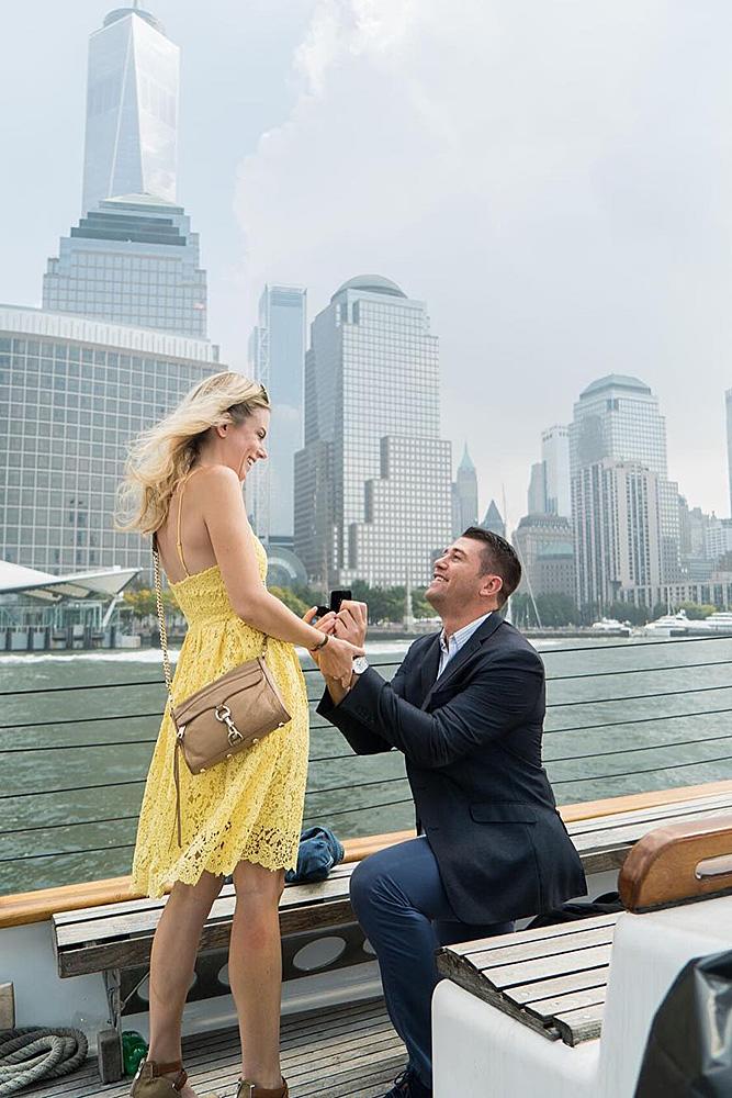 engagement photo ideas man propose a woman boat city view