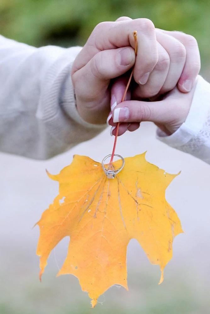 fall proposal ideas two hands with yellow leave and engagement ring idea