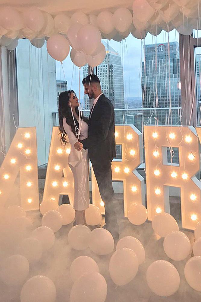 engagement pictures man and woman stand holding balloons