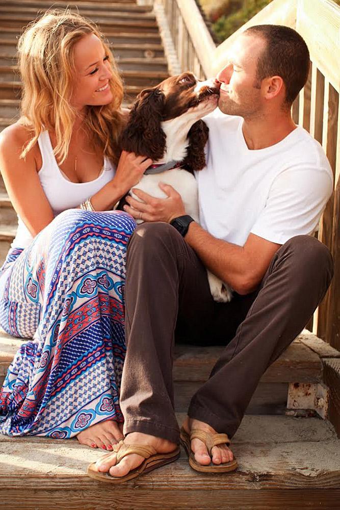 engagement pictures with pets dog kisses a man the girl is smiling