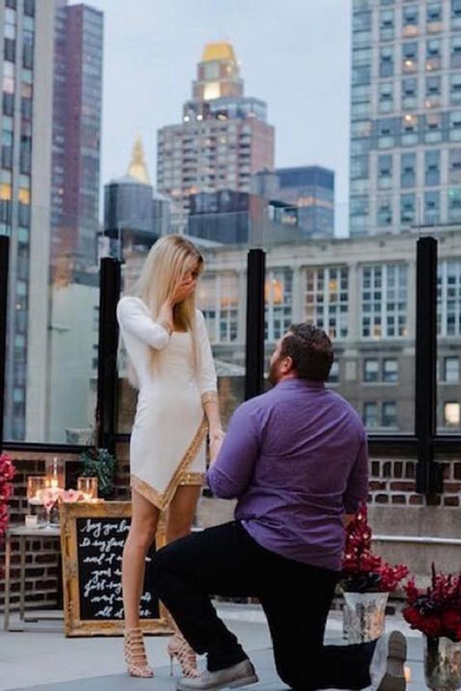 wedding proposal on the roof with flovers and candles she amazed