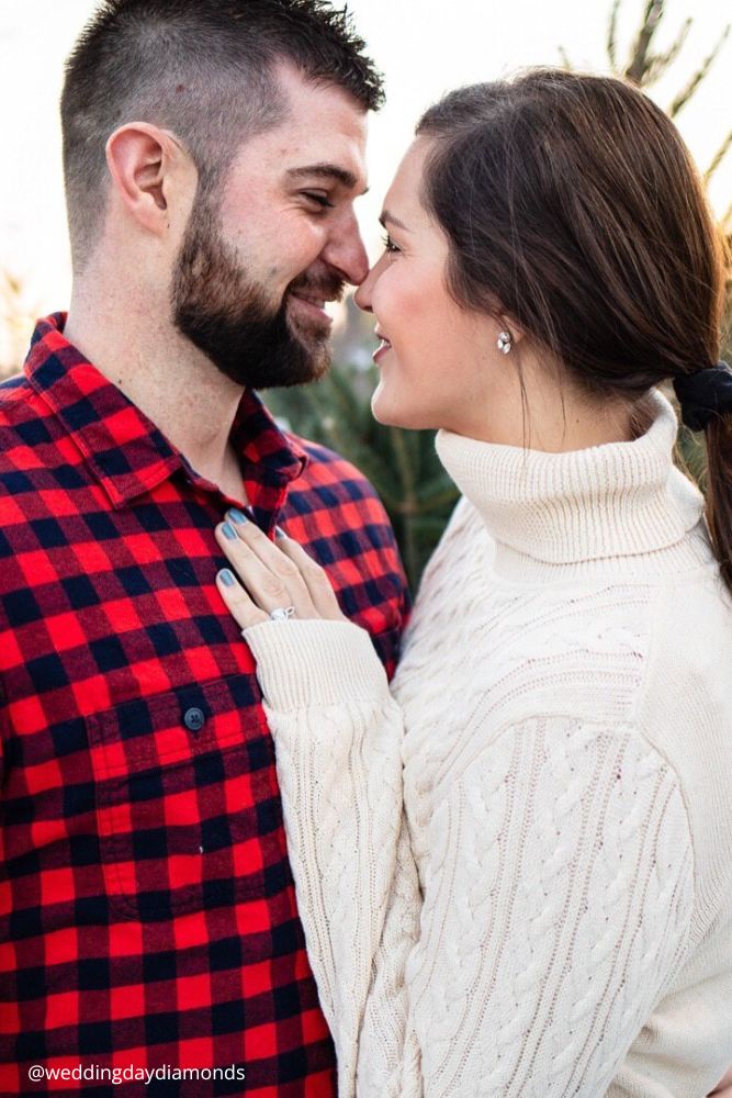 new year engagement photos a man and woman standing next to each other in front of a trees weddingdaydiamonds