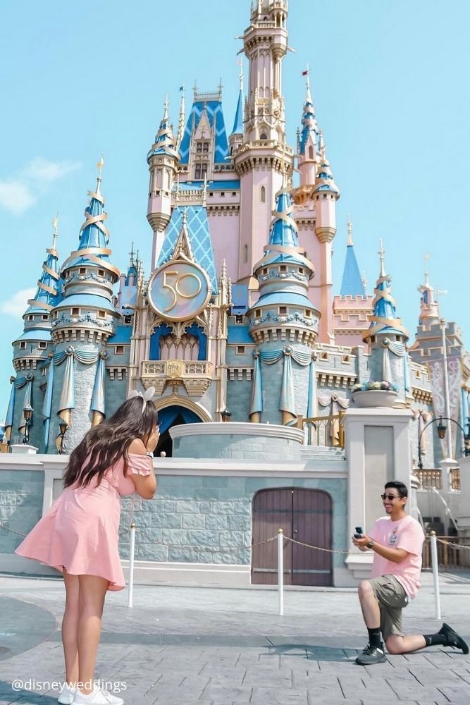 disney proposal ideas a guy in pink shirt rooses to a girl dresses in minnie mouse style at the disney castle disneyweddings
