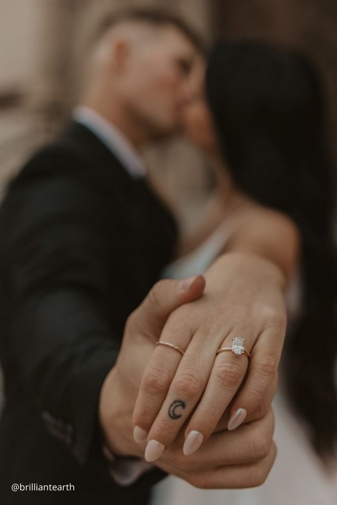 winter engagement photos couple shows their hands with rings brilliantearth