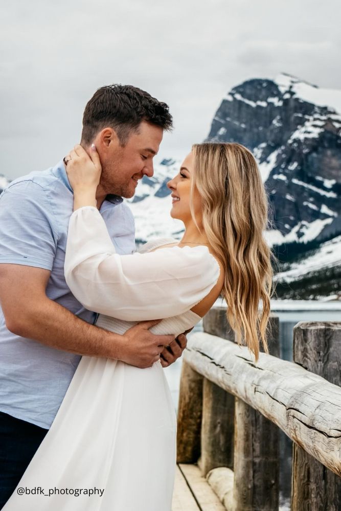 winter engagement photos couple stands in the snowy mountains bdfk photography