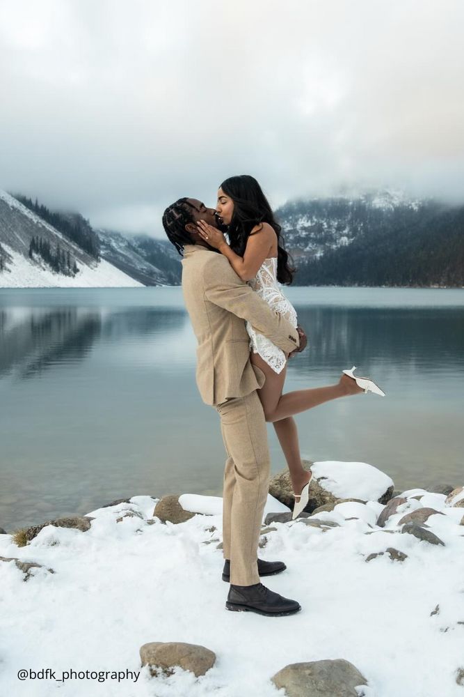 winter engagement photos kissing couple in the mountains at the lake bdfk photography