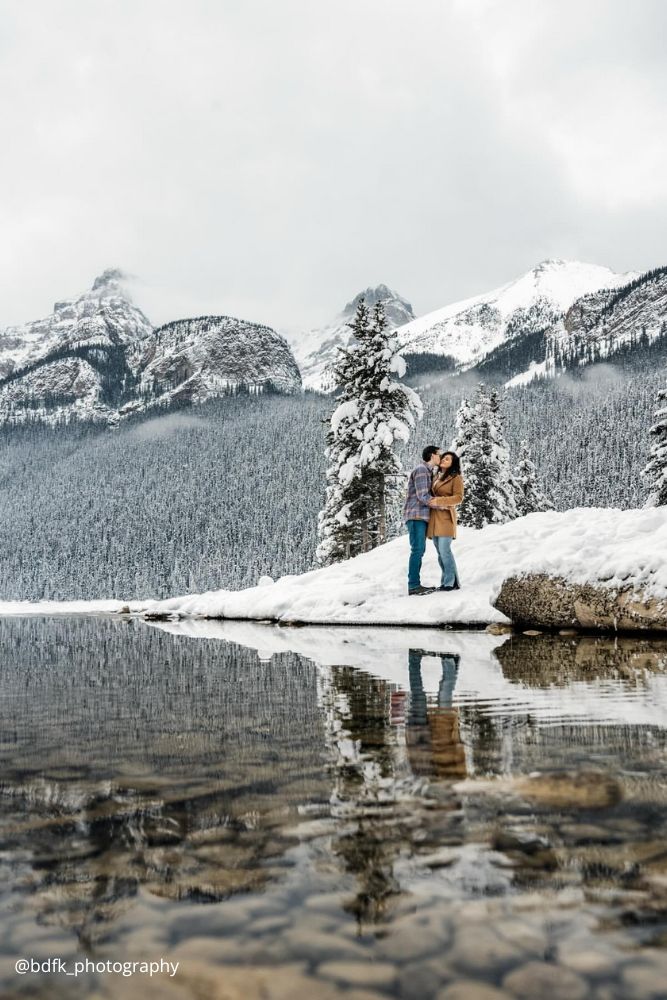 winter engagement photos kissing couple on the lakeside snowy winter bdfk photography