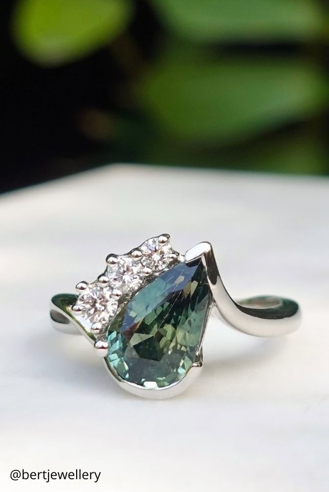 white gold engagement rings asymmetrical pear shaped teal sapphire ring with three side diamonds in white gold bertjewellery