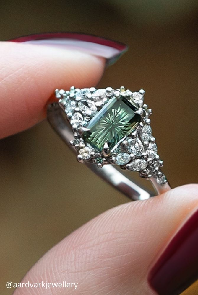 white gold engagement rings emerald cut green gemstone ring with intricate diamond cluster in white gold aardvarkjewellery