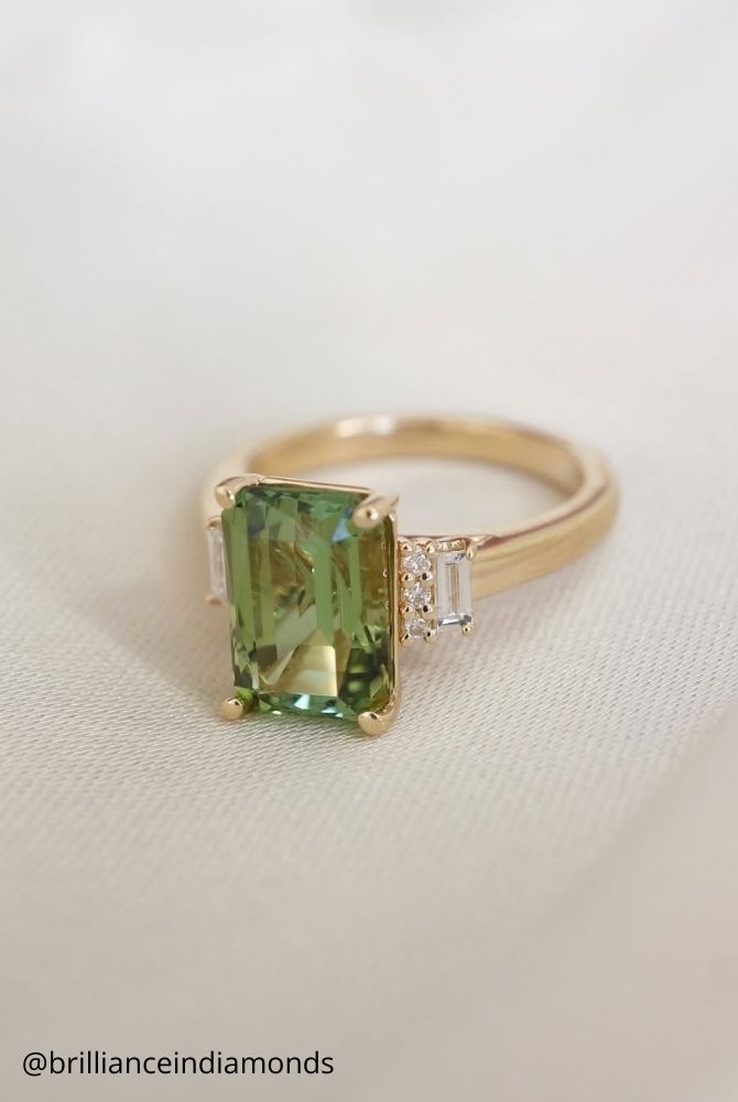 unique engagement rings emerald cut green tourmaline engagement ring with rectangular gemstone in yellow gold featuring baguette diamond side stones brillianceindiamonds