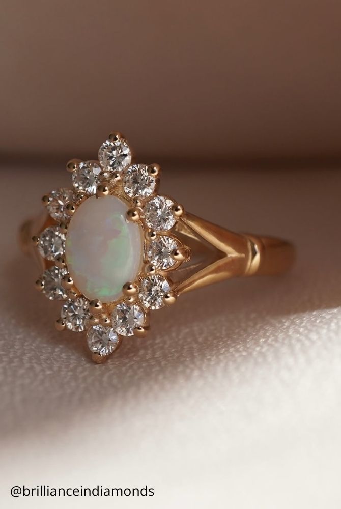 unique engagement rings oval shaped opal sits at the center halo of round diamonds then set in a bold split shank setting brillianceindiamonds