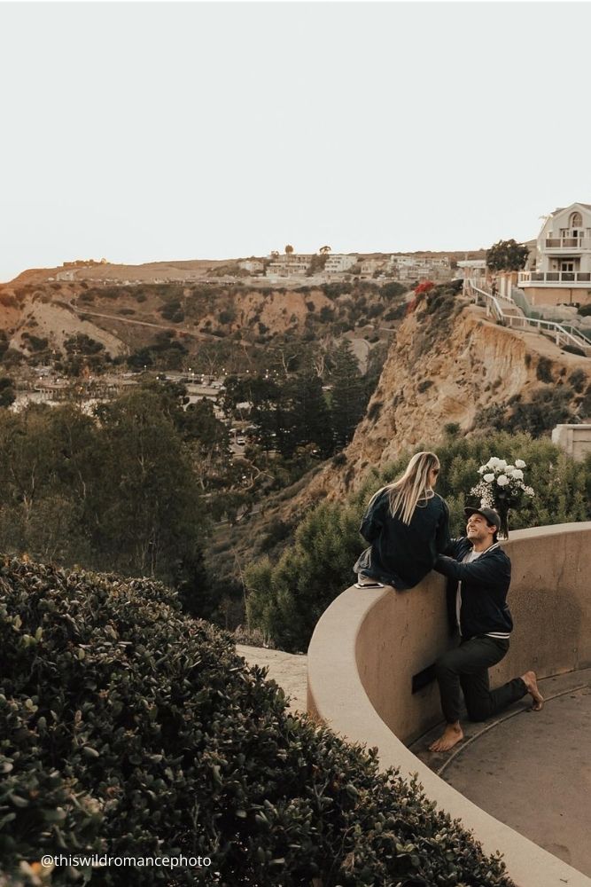 cheap proposal ideas a guy proposes to a girl on a ledge overlooking a city thiswildromancephoto