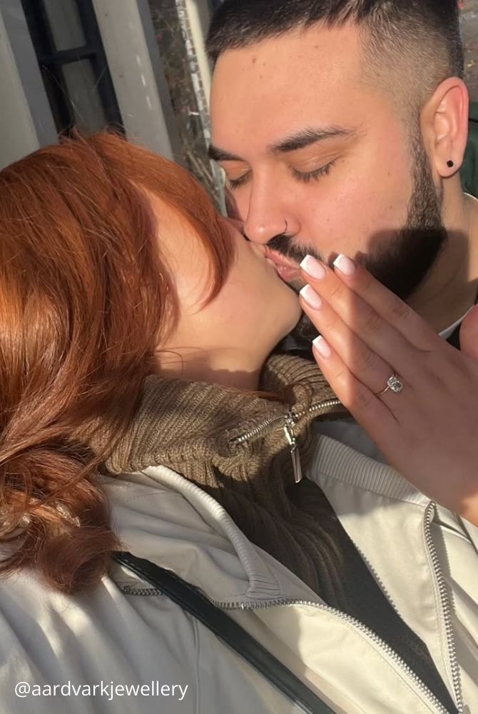 cheap proposal ideas close up of couple kissing while woman shows off new engagement ring aardvarkjewellery