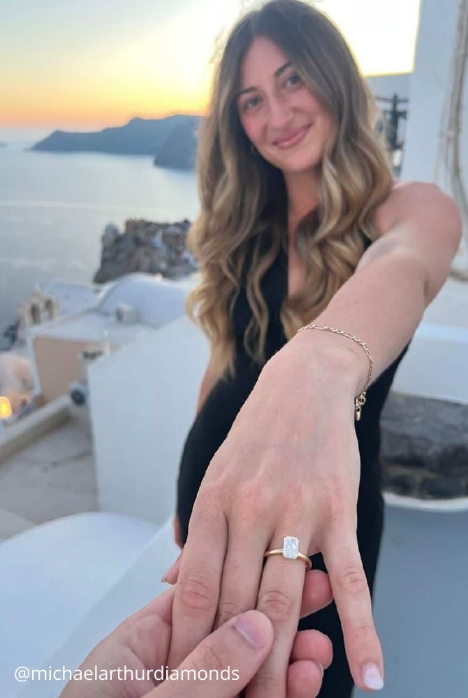 cheap proposal ideas womans hand showing engagement ring michaelarthurdiamonds