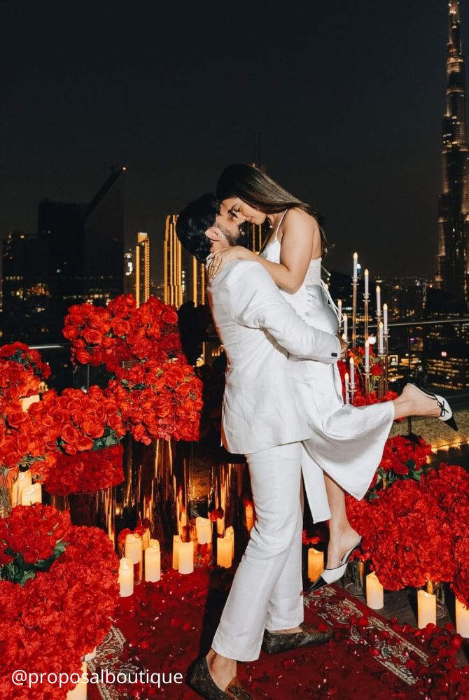 engagement photos creative proposal beautiful photozone he holds her in his hands many red roses proposalboutique
