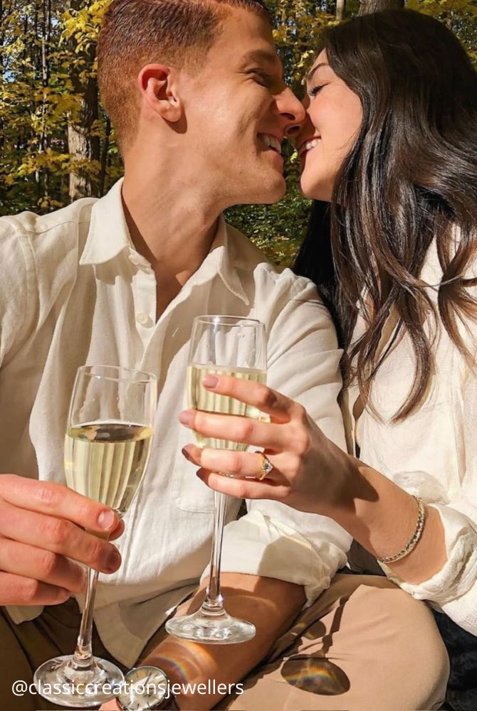 engagement photos lovers with glasses in hand embracing classiccreationsjewellers