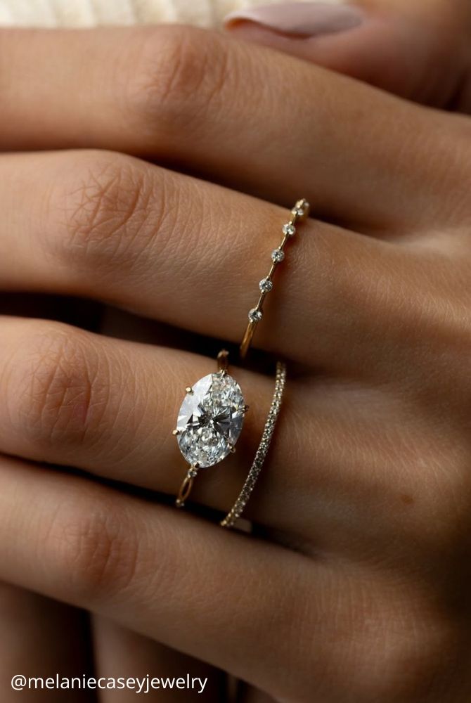 solitaire engagement rings yellow gold oval stone ring ring on the hand delicate fragile melaniecaseyjewelry