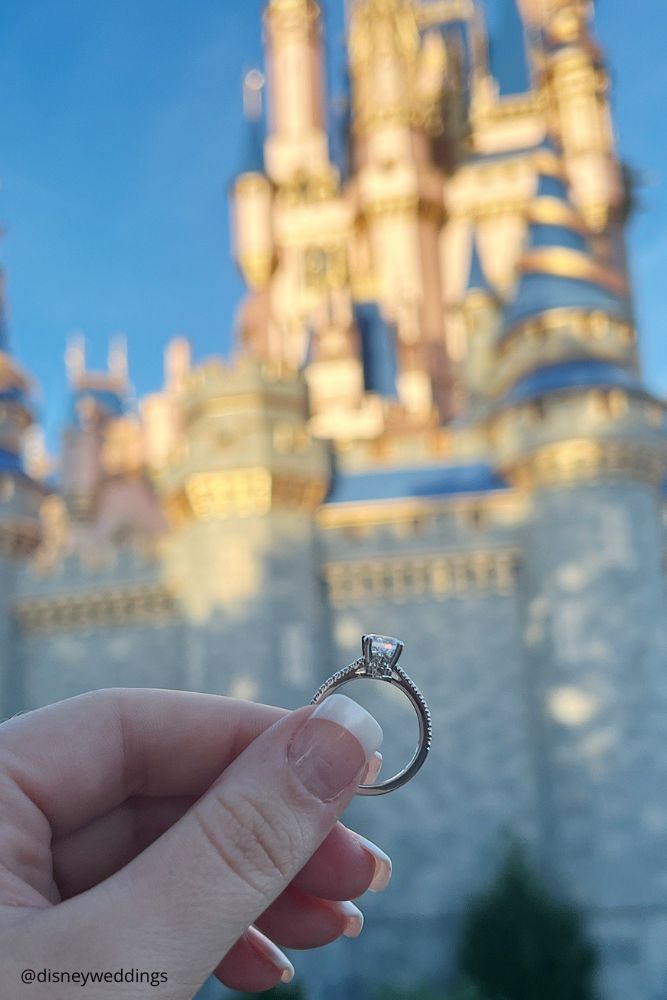 christmas proposal engagement with the disney castle on the background disneyweddings